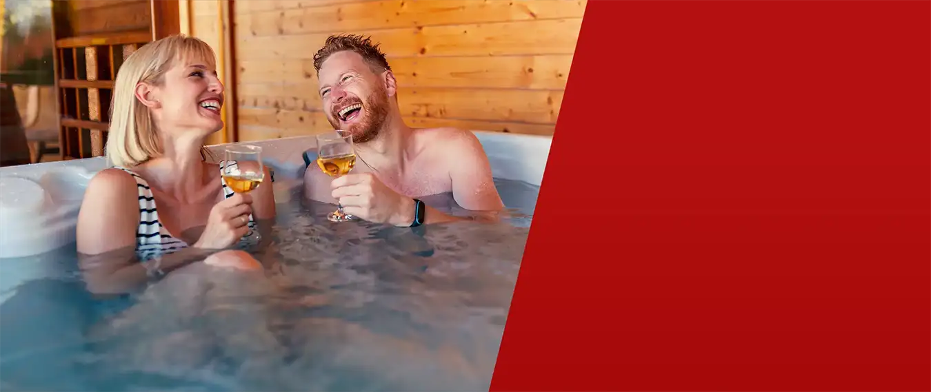 Couple enjoying drinks in a hot tub at home during evening relaxation