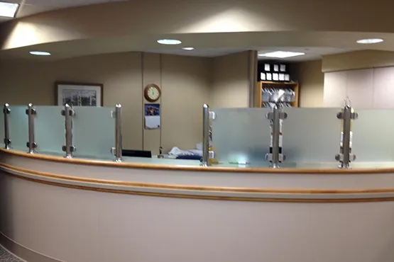 Modern showroom counter with frosted glass panels displaying pool supplies and spa accessories