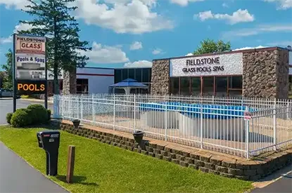 Home Fieldstone Glass Pool & Spas storefront with above ground pools displayed behind white fencing
